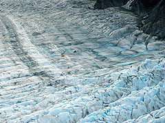 Tiny people and helicopter on the huge glacier