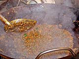 Mixing basil into darkened eggplant mixture