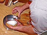 Grating fresh coconut for crepe filling