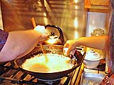 Sprinkling catfish flakes into very hot oil