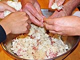 Mixing steamed and cooled sticky rice with seasoned pork