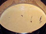 Simmering slices of browned beef in coconut milk